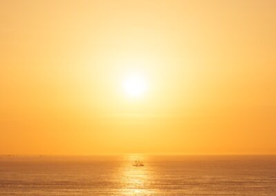 A small boat on the ocean at sunset.